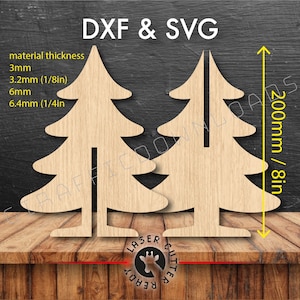 May include: Two wooden Christmas tree cutouts, 8 inches tall, with a slot for assembly. The image includes text: DXF & SVG, material thickness: 3mm, 3.2mm (1/8in), 6mm, 6.4mm (1/4in).