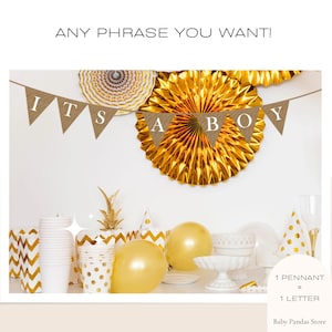May include: A burlap banner with the words "It's a Boy" in white letters. The banner is strung between two gold paper fans. The banner is decorated with gold and white polka dot paper cups and balloons.