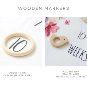 May include: Two wooden markers for a baby milestone blanket. One is a ring with the number 10 written on it. The other is a bird shape with a hole in the middle. The text "10 WEEKS" is written on the blanket.