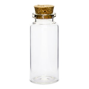 Puede incluir: Una botella de vidrio transparente con un tap&oacute;n de corcho. La botella est&aacute; vac&iacute;a y tiene una forma cil&iacute;ndrica.