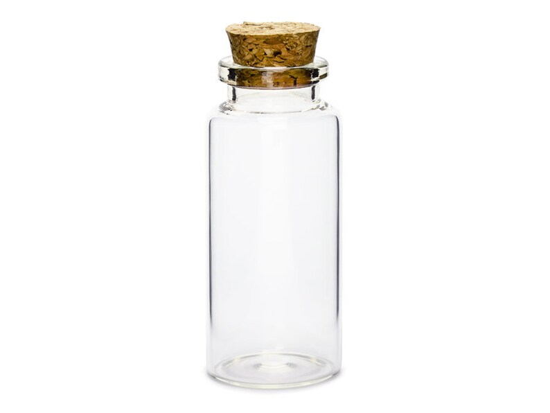 Puede incluir: Una botella de vidrio transparente con un tap&oacute;n de corcho. La botella est&aacute; vac&iacute;a y tiene una forma cil&iacute;ndrica.