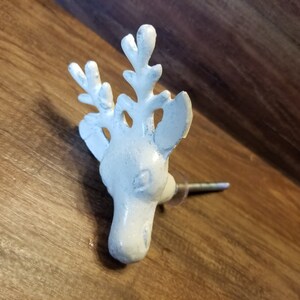 May include: White ceramic deer head knob with antlers. The knob is attached to a metal screw.