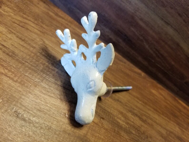 May include: White ceramic deer head knob with antlers. The knob is attached to a metal screw.