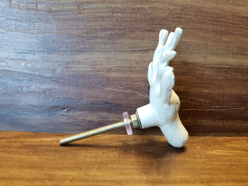 May include: White ceramic deer head door knob with a silver screw and a pink washer.