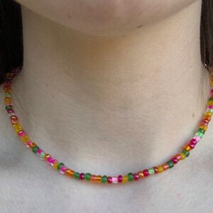 May include: A colorful beaded necklace with pink, green, orange, and yellow beads.