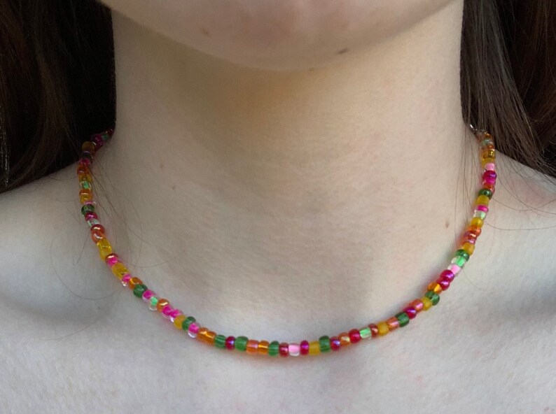 May include: A colorful beaded necklace with pink, green, orange, and yellow beads.