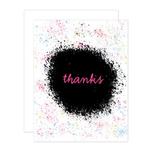 Puede incluir: Una tarjeta blanca con un diseño de pintura salpicada negra. El centro de la tarjeta tiene un círculo negro grande con la palabra "gracias" escrita en rosa.
