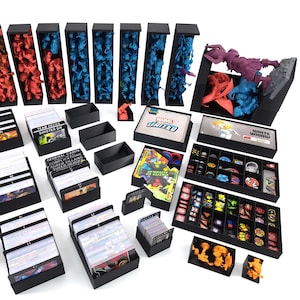 Puede incluir: Bandejas organizadoras de plástico negro para el juego de mesa Marvel United. Las bandejas contienen figuras en miniatura, cartas y dados. Las bandejas están etiquetadas con los nombres de los personajes y los componentes del juego. La caja del juego también es visible en la imagen.