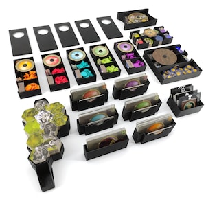 Op de afbeelding: Een zwarte organizer met meerdere vakken om spelstukken en kaarten op te bergen. De organizer is ontworpen voor een bordspel en bevat vakken voor tokens, dobbelstenen en kaarten.