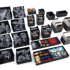Puede incluir: Un conjunto de organizadores de plástico negro para componentes de juegos de mesa. Los organizadores están llenos de varias piezas de juego, incluyendo dados, cartas y miniaturas.