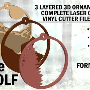 Puede incluir: Ornamento 3D de tres capas con una escena de montaña, un árbol y un círculo. El ornamento está hecho para corte láser o corte de vinilo. Los formatos de archivo incluidos son SVG, PDF, EPS y AI. El texto "The WOLF" está en la parte inferior de la imagen.