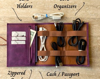 May include: A purple leather travel organizer with a zippered pouch, card holders, and a cash/passport pocket. The organizer has multiple slots for cords and cables.