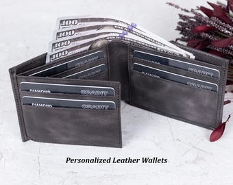 Puede incluir: Una cartera de cuero gris con múltiples ranuras para tarjetas y un compartimento para efectivo. La cartera está abierta y tiene varias tarjetas de crédito y efectivo en su interior.