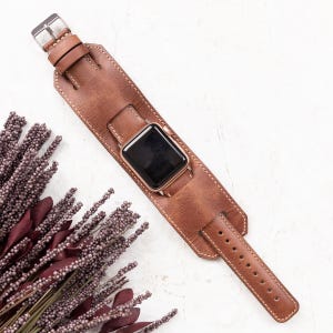 Handcrafted genuine leather cuff watch band with a vintage style, designed for a bold and unique look. Custom engraving available for names, initials, or logos. Compatible with Apple Watch Ultra, Series 10, 9, 8, 7, 6, 5, 4, 3, 2, 1, SE (38mm, 40mm, 41mm, 42mm, 44mm, 45mm, 49mm), Samsung Galaxy, Fitbit, Google Pixel, Fossil, and Garmin watches