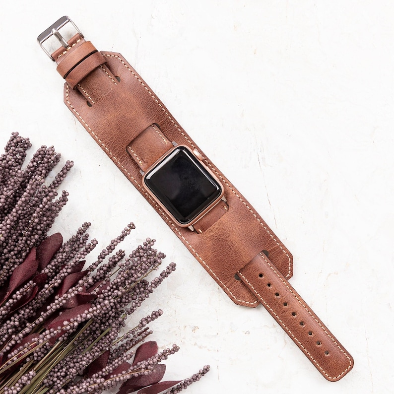 Handcrafted genuine leather cuff watch band with a vintage style, designed for a bold and unique look. Custom engraving available for names, initials, or logos. Compatible with Apple Watch Ultra, Series 10, 9, 8, 7, 6, 5, 4, 3, 2, 1, SE (38mm, 40mm, 41mm, 42mm, 44mm, 45mm, 49mm), Samsung Galaxy, Fitbit, Google Pixel, Fossil, and Garmin watches
