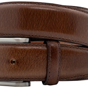 May include: A brown belt with a textured surface and visible stitching along the edges. The belt features a rectangular silver-toned metal buckle with a single prong and a matching leather keeper loop to secure the strap in place.