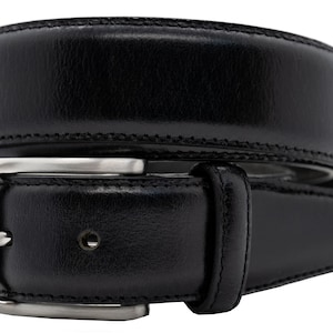 May include: A black leather belt featuring a smooth, polished finish and a rectangular silver-toned metal buckle. The belt strap has visible stitching along the edges and a single belt loop near the buckle, coiled into a circular shape.