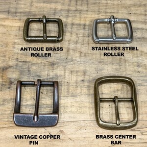 May include: Four metal belt buckles in antique brass, stainless steel, vintage copper, and brass. Each buckle has a different design, including roller and pin styles. The text labels each buckle's material and style.