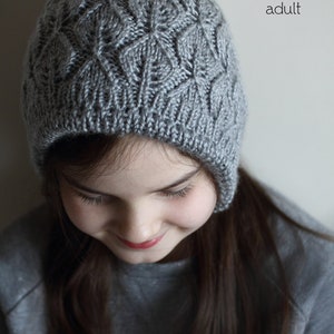 May include: A grey knitted hat with a textured diamond pattern, suitable for newborns to adults. The hat is made of soft yarn. The text "PDF Knitting Pattern" and "sizes: newborn to adult" are visible. The hat is shown on a person.