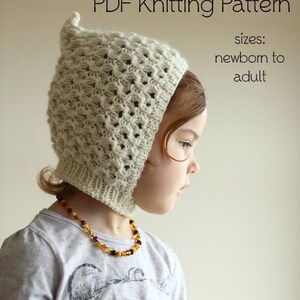 Könnte beinhalten: Ein PDF-Strickmuster für eine cremefarbene Strickhaube mit strukturiertem Design. Die Haube wird an einem Kind gezeigt und ist für Neugeborene bis Erwachsene geeignet. Die Haube hat eine spitze Oberseite und einen gerippten Bund.