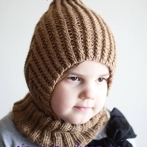 Peut inclure: Un ensemble bonnet et cache-cou tricoté en marron avec un sommet pointu. Le bonnet est conçu pour couvrir les oreilles et le cou. L'ensemble est disponible en tailles allant du nouveau-né à l'adolescent. "PDF Knitting Pattern" est écrit en texte violet en haut de l'image.