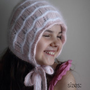 Op de afbeelding: Een roze en witte gebreide muts met een puntige top en een lange stropdas. De muts wordt gedragen door een kind met lang bruin haar. De tekst "PDF Knitting Pattern" en "sizes: newborn to adult" is zichtbaar in de afbeelding.