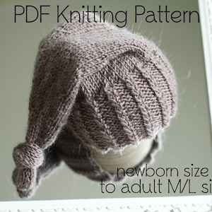 Puede incluir: Patrón de tejido de punto PDF para un gorro marrón con un diseño de punto de cable. El gorro se muestra en un maniquí blanco y el texto "newborn size to adult M/L size" es visible debajo del gorro.
