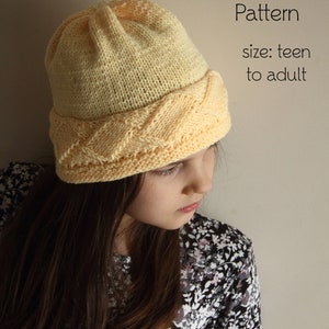 May include: A yellow knitted hat with a cable stitch pattern. The hat is sized for a teen to adult. PDF Knitting Pattern.
