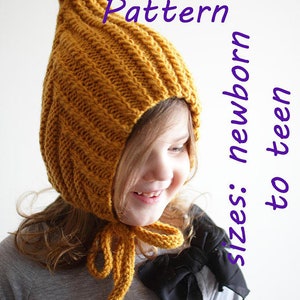 Op de afbeelding: Een gele gebreide muts met een puntige kap en een strik. De muts wordt gedragen door een kind en de tekst "PDF Knitting Pattern Sizes: newborn to teen" is zichtbaar op de afbeelding.