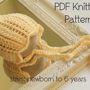 Op de afbeelding: Een gele gebreide baby muts met een puntige top en een lange stropdas. De muts ligt op een wit oppervlak met een spiegel en een wit frame. De tekst "PDF Knitting Pattern" en "sizes: newborn to 6 years" is zichtbaar in de afbeelding.