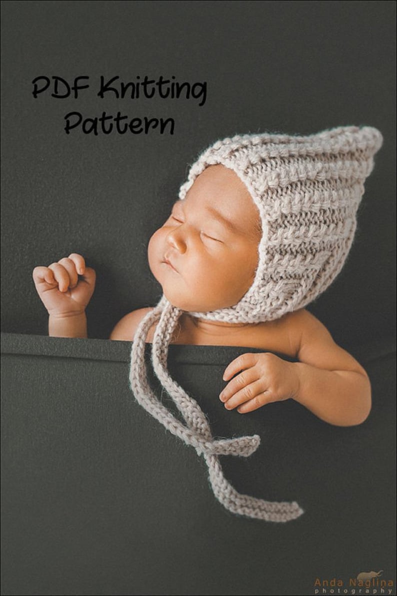 Peut inclure: Un patron de tricot PDF pour un bonnet de b&eacute;b&eacute;. Le bonnet est de couleur beige clair et pr&eacute;sente un motif de point simple. Le bonnet est nou&eacute; avec une longue ficelle fine.