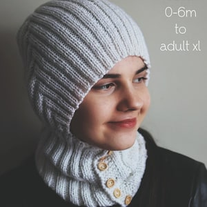 May include: A knitted white balaclava with a buttoned cowl. The balaclava is made of a ribbed knit fabric. The text "PDF Knitting Pattern" is at the top of the image, with size options from 0-6 months to adult XL.