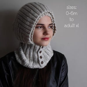 May include: A light gray knitted hood and cowl set with three brown buttons. The hood is attached to the cowl and covers the head and neck. The text "PDF Knitting Pattern" is at the top, with size options from 0-6m to adult xl.