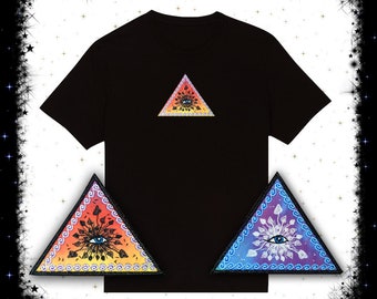May include: Black t-shirt with a colorful triangle design featuring an eye and floral patterns. Two additional iron-on patches are included, one with a blue and white design and one with a red and orange design.