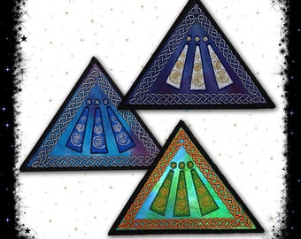 May include: Three embroidered triangular patches with a Celtic knot border. The patches are in shades of blue, green, and purple with a white, gold, and green design in the center.