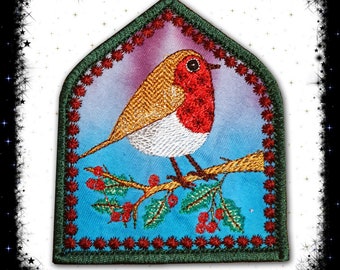 May include: A red-breasted robin perched on a holly branch with red berries. The robin is embroidered on a blue background with a green and red border. The image is in the shape of an arched window.