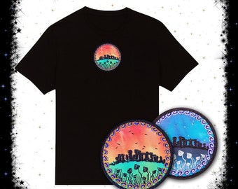 May include: A black t-shirt with a circular design featuring a silhouette of Stonehenge with a sunset sky and green grass. Two round patches are also shown, one with a sunset sky and the other with a night sky.