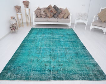 May include: A teal blue vintage rug with a faded pattern. The rug has a distressed look and is perfect for adding a touch of bohemian style to any room.