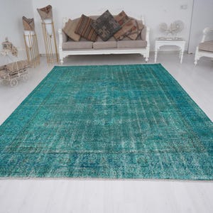 May include: A teal blue vintage rug with a distressed look. The rug has a faded, worn appearance with a subtle pattern.
