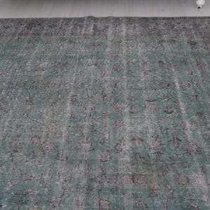 May include: A vintage teal and gray rug with a faded floral pattern. The rug has a distressed look and is made of a soft, woven material.