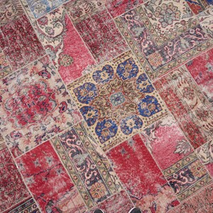 K&ouml;nnte beinhalten: Ein Patchwork-Teppich mit verschiedenen Farben und Mustern, darunter Rot, Blau und Beige. Der Teppich besteht aus verschiedenen Stoffst&uuml;cken, die zusammengen&auml;ht wurden.