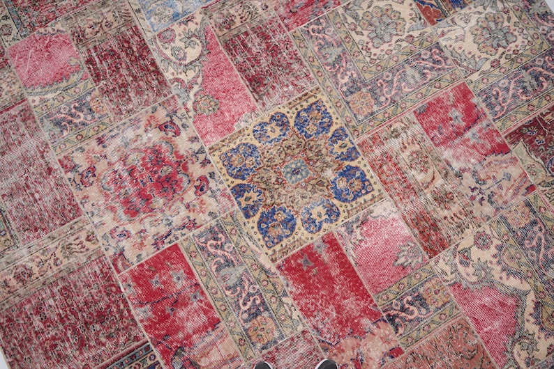 K&ouml;nnte beinhalten: Ein Patchwork-Teppich mit verschiedenen Farben und Mustern, darunter Rot, Blau und Beige. Der Teppich besteht aus verschiedenen Stoffst&uuml;cken, die zusammengen&auml;ht wurden.