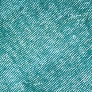 May include: A close-up of a teal blue textured fabric with a subtle grid pattern.