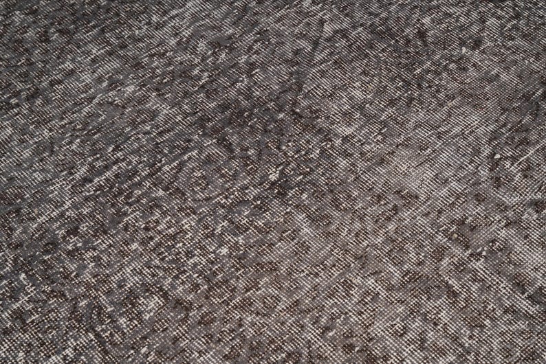 May include: A close-up of a gray and white patterned rug with a textured surface.
