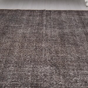 May include: A dark gray area rug with a subtle pattern. The rug has a distressed look and is made of a soft, woven material.