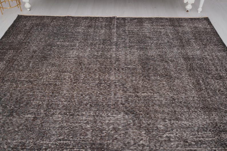 May include: A dark gray area rug with a subtle pattern. The rug has a distressed look and is made of a soft, woven material.
