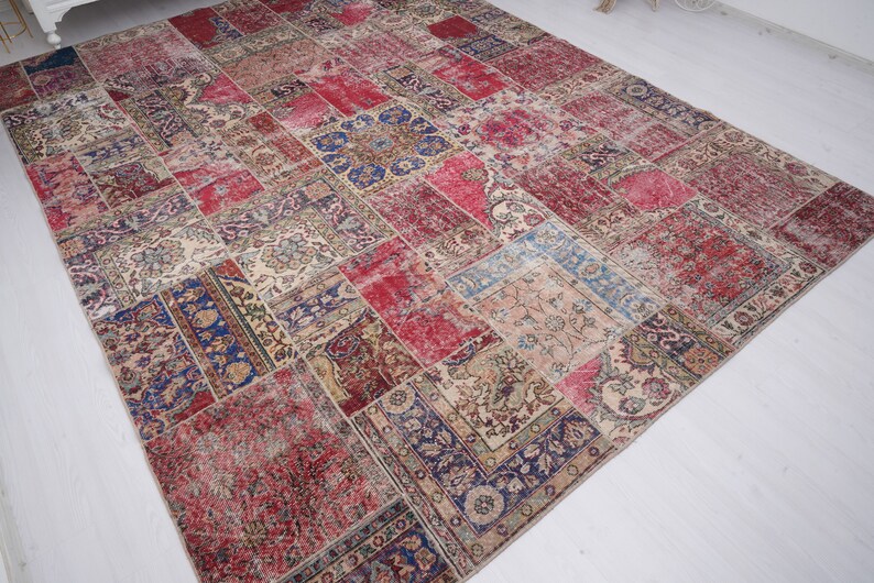 K&ouml;nnte beinhalten: Ein Patchwork-Teppich mit verschiedenen Farben und Mustern, darunter Rot, Blau und Beige. Der Teppich besteht aus verschiedenen Stoffst&uuml;cken, die zusammengen&auml;ht wurden.
