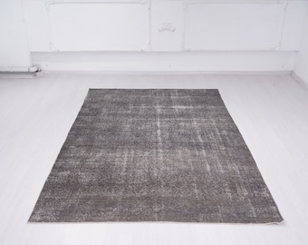May include: A distressed gray area rug with a subtle pattern. The rug has a faded, vintage look and is made of a soft, durable material.