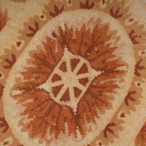 Puede incluir: Primer plano de una alfombra de color beige y marr&oacute;n con un dise&ntilde;o central de un sol estilizado.