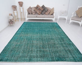 May include: A teal blue vintage rug with a distressed look. The rug has a subtle pattern and is perfect for adding a touch of bohemian style to any room.
